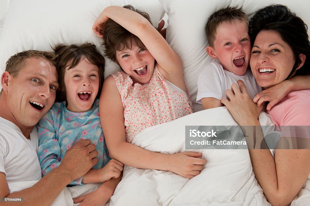 Familia en la cama - Foto de stock de 10-11 años libre de derechos