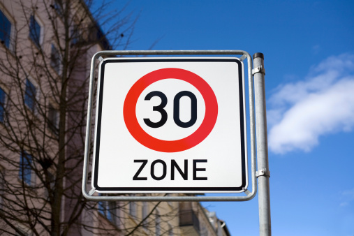 German traffic sign - speed limit 30 kilometers per hour, selective focus, low-angle view