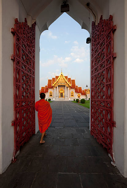Monk walking through the entrance, Marble Temple,Bangkok.