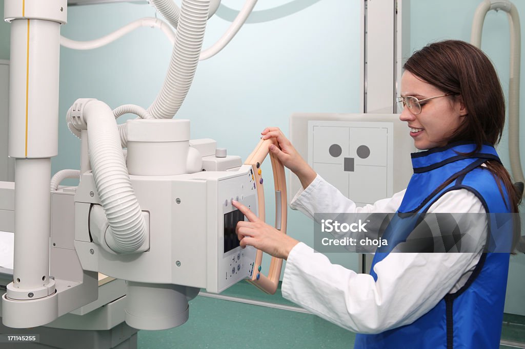 Young radiologist working with modern X-ray machine Protection Stock Photo