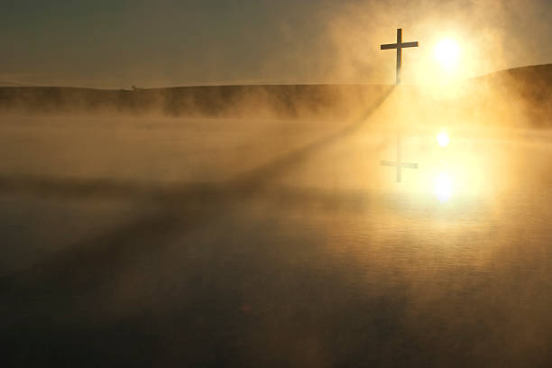 Single Cross Long Shadow Sunrise on Foggy Lake Easter Morning stock photo