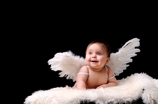 gorgeus little girl smiling with her angel wings.