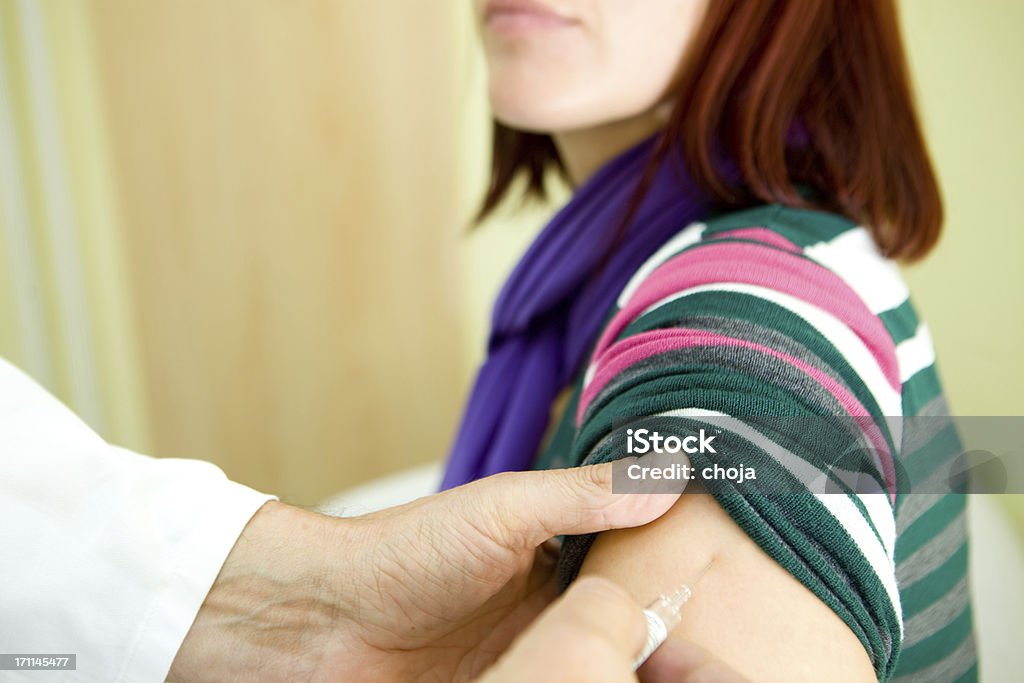 Infermiere presso work.injecting vaccino per l'influenza - Foto stock royalty-free di Composizione orizzontale