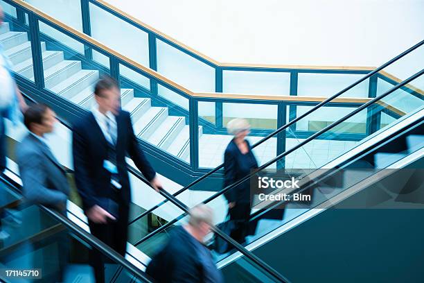 Gente De Negocios En Movimiento Borroso En Escaleras Mecánicas Foto de stock y más banco de imágenes de Actividades bancarias