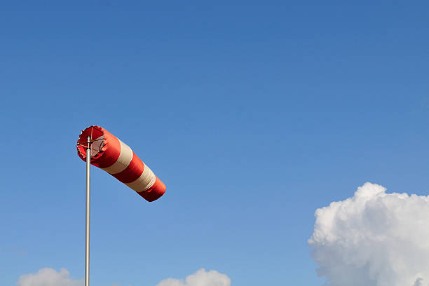 rouge et blanc protège contre le vent et un ciel bleu. - weather vane photos et images de collection