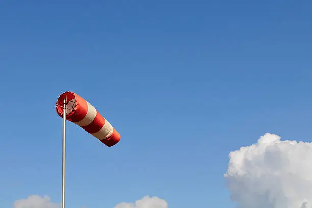 Wind sign against a blue sky with some clouds