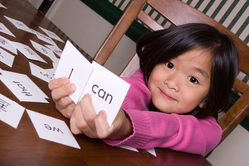 Little girl expresses positivity by holding up sight words that say 
