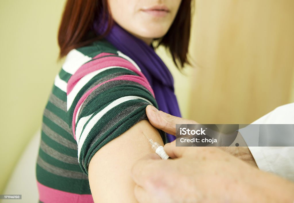 Gripe vaccination.of una mujer joven en el trabajo, el personal de enfermería - Foto de stock de Inyectar libre de derechos