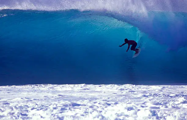 Photo of surfer on a blue wave