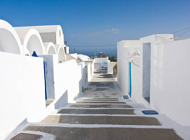 whitewashed houses beside an alley in Santorini / Greece