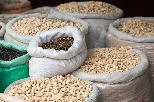 Young Asian woman doing grocery shopping in a supermarket, close up of her hand choosing a pack of organic mixed beans. Healthy eating lifestyle.