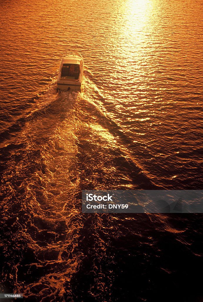 Into the Sunset Pleasure boat cruising off into the sunset Bay of Water Stock Photo