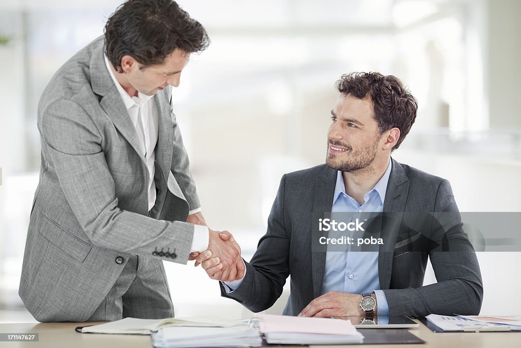 Deux hommes d'affaires se serrant la main dans la salle de conseil - Photo de Adulte libre de droits