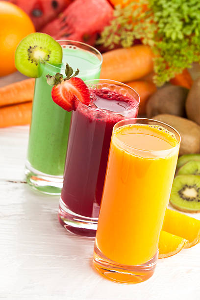 istock Three glasses of fruit juices and garnish on white table 171147928