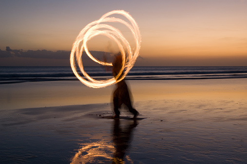 Fire show on the beach at sunset
