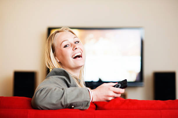 istock Laughing blonde in lounge with TV remote control 171148315