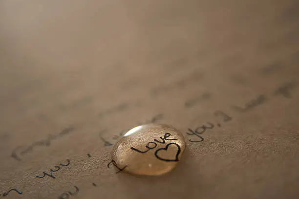 Photo of A love letter written on brown paper with a gold love heart 
