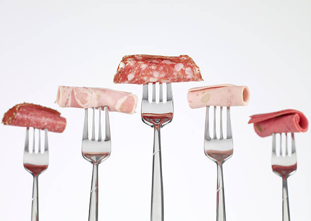Salami on fork, still-life.