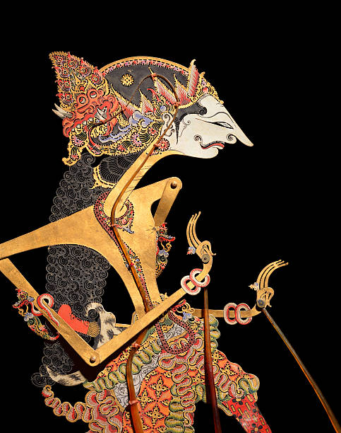 Wayang Puppet Javanese shadow puppet on black background. These puppets (Bali, early 20th century), made of buffalo hide, are used in wayang kulit aEshadow puppet playaa. The term 'wayang' was derived from Javanese word for "shadow". Wayang Kulit plays are invariably based on romantic tales, especially adaptations of the classic Indian epics, "The Mahabarata" and "The Ramayana". wayang kulit photos stock pictures, royalty-free photos & images