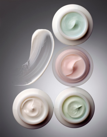 High angle view of 4 opened face cream pots (+clipping path)