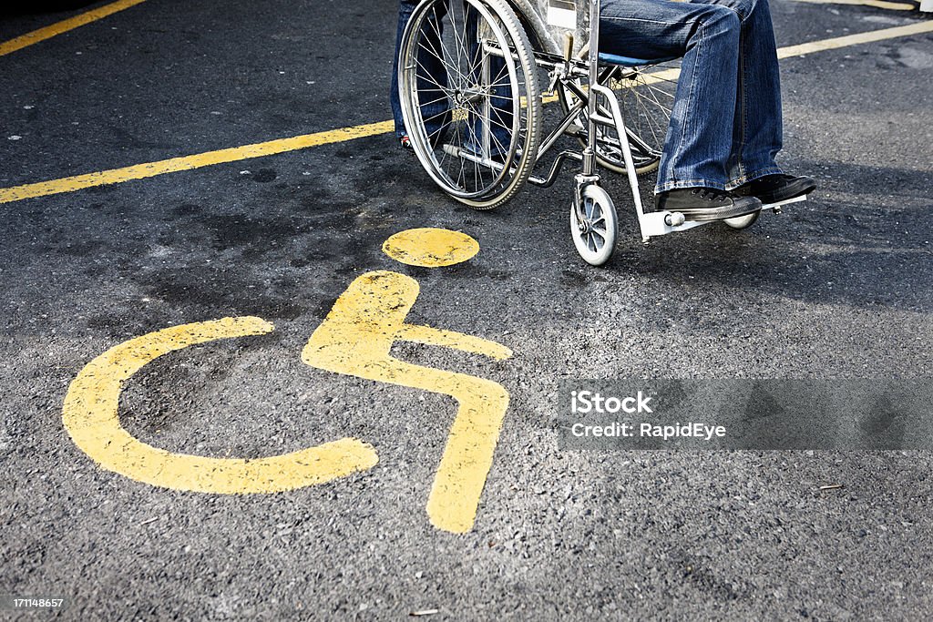 Personne en fauteuil roulant à côté d'un parking réservé - Photo de Parking libre de droits