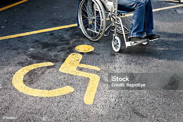 Foto de Pessoas Em Cadeira De Rodas Ao Lado De Uma Placa De Estacionamento Para Visitantes Com Necessidades Especiais e mais fotos de stock de Estacionamento de carros