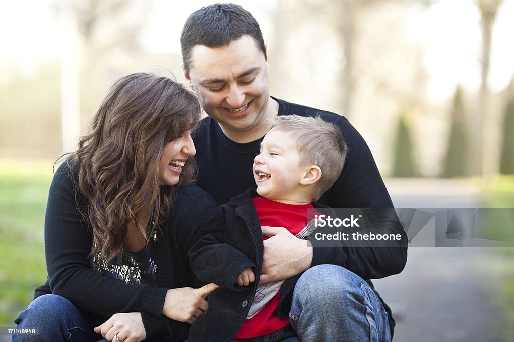 young family at the park young parents and son smiling and laughing, sitting in the park Affectionate Stock Photo