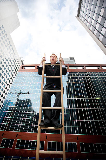 istock funny businessman Hangs Onto the corporate ladder 171148986