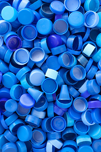 Lots of blue plastic bottle caps