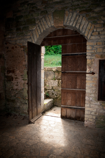 View through ancient wooden doorway of a sunny scene