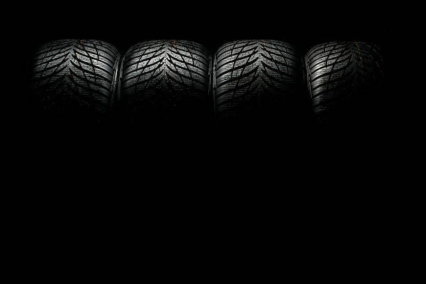 row of brand new, high performance winter tyre on black background. You can drive your car safety on snow and slush.see my