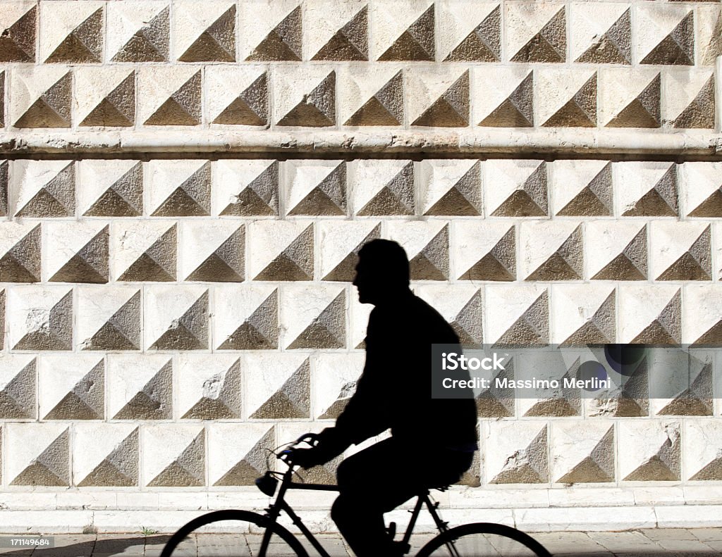 Person Riding Bicycle Beautiful architecture in Ferrara, Italy. Ferrara Stock Photo