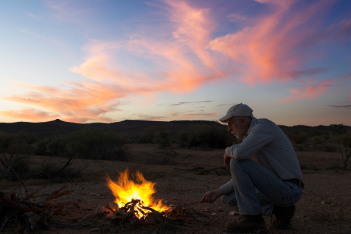 A Man tends a campfire in outback South Australia
