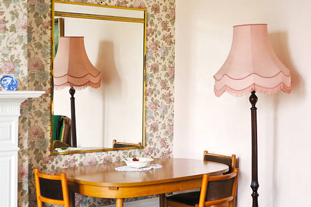 Interior design detail of a luxury country hotel room with wooden bed and bedside table. Floral print wallpaper. High quality horizontal photo