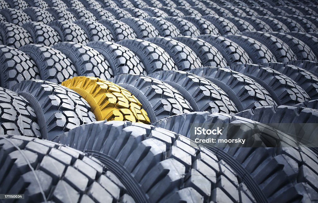 Wheels Warehouse of tires, one gold tire in a row of usual ones. Creativity Stock Photo