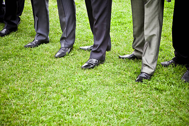 Businesspeople standing in a row on the lawn.