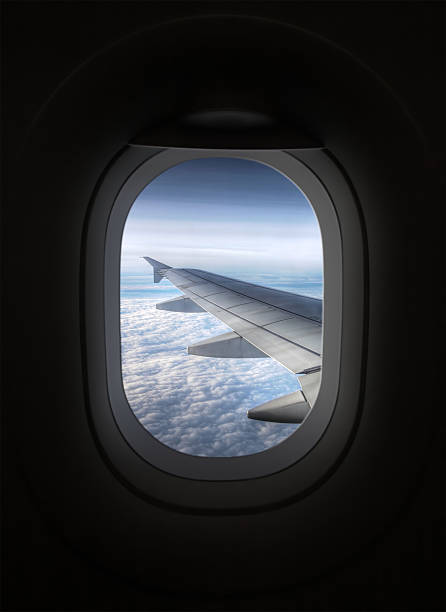 vista da interno di aereo attraverso la finestra alla ala di aeroplano - window porthole sky cloudscape foto e immagini stock