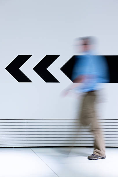 Man walking in opposite direction of arrow
