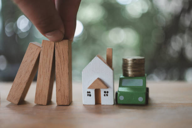 istock Hands stop domino effect before destroy home, car and coin before fail. 1711505406