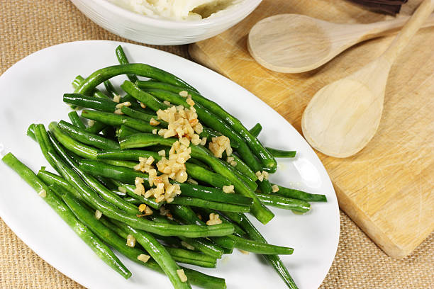 Fresh green beans serves with crushed nuts Whole Green beans sautéed with olive oil and garlic green bean stock pictures, royalty-free photos & images