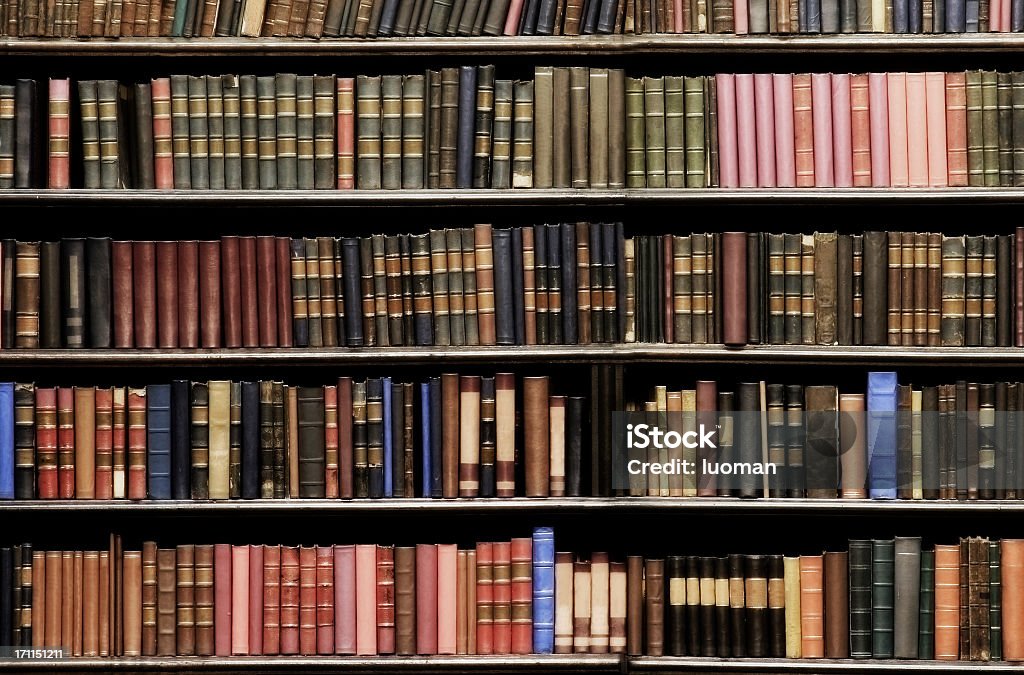 Old books in a library Desaturated colors. Old books in a library Bookshelf Stock Photo