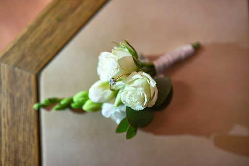 A white rose and a wedding ring. Preparation for the wedding celebration.