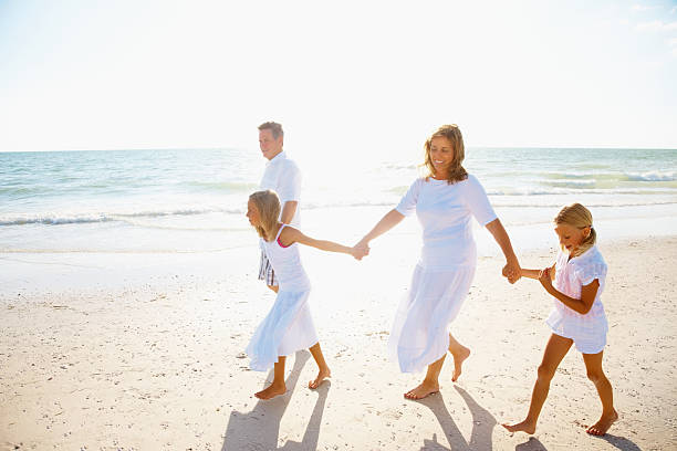 istock Happy family holding hands while walking on a beach 171151342