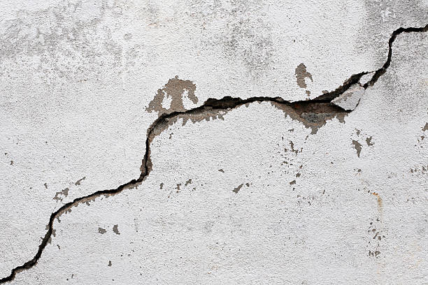 A big crack on an old, rotten wall cracked wall background. earthquake stock pictures, royalty-free photos & images