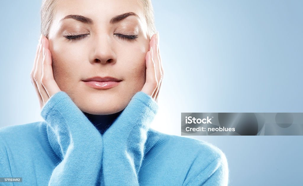 Close-up bellissimo volto di giovane donna con blu maglia - Foto stock royalty-free di Massaggio del viso