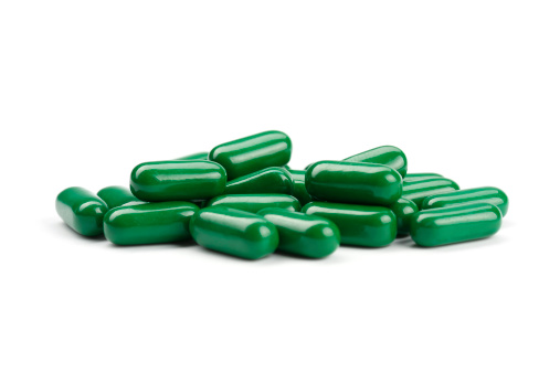 group of nutritional supplement green pills on white backgroundsee my