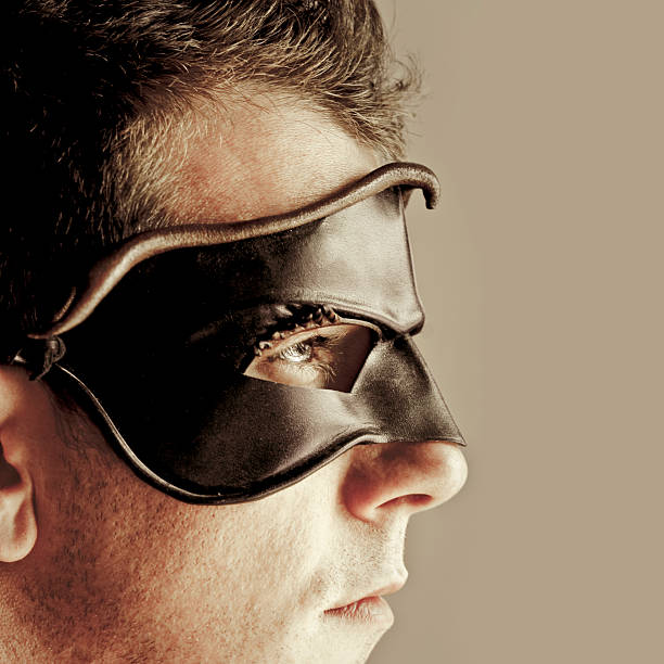 Man with Leather Mask and Costume. Close up on face, peering off into the distance.