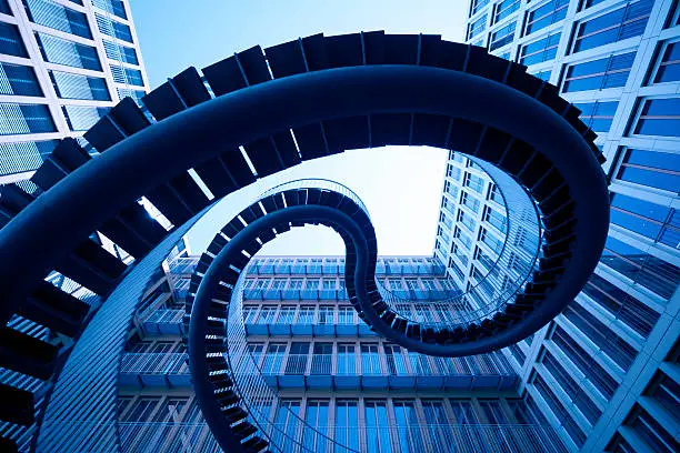 Photo of spiral stiars in front of modern architecture