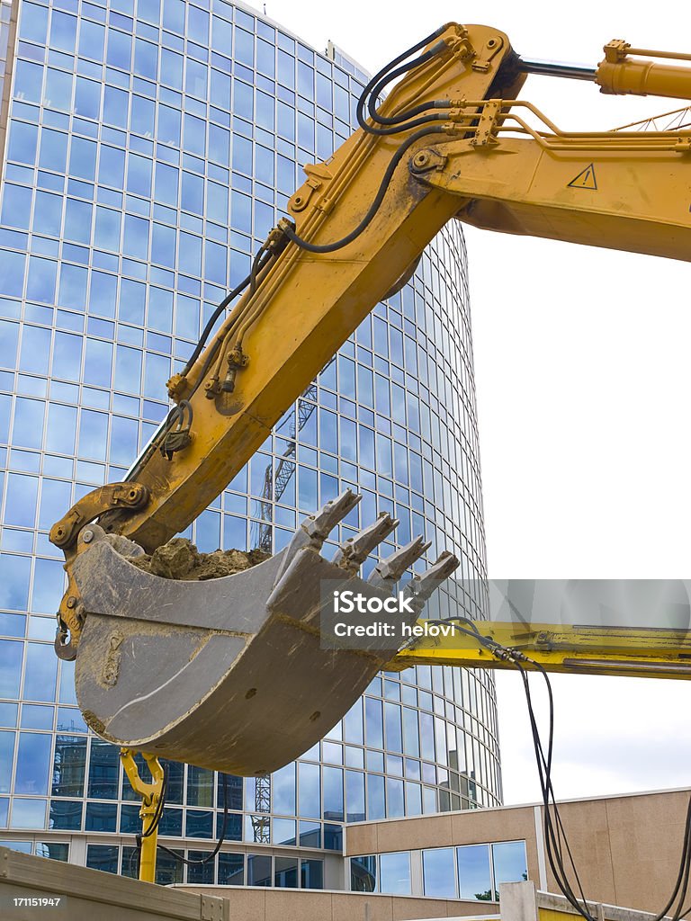 Excavator contra edificio de vidrio - Foto de stock de Cavadora mecánica libre de derechos