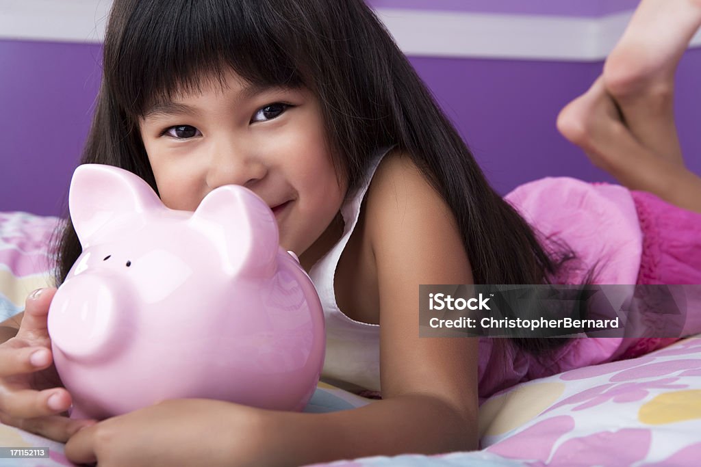 Lächelnd asiatische Mädchen holding Sparschwein - Lizenzfrei Ersparnisse Stock-Foto